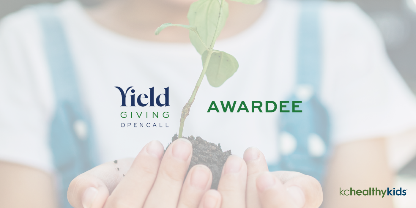A close up image of a child's hands holding a seedling overlaid with text reading Yield Giving Open Call Awardee and KC Healthy Kids' logoPicture